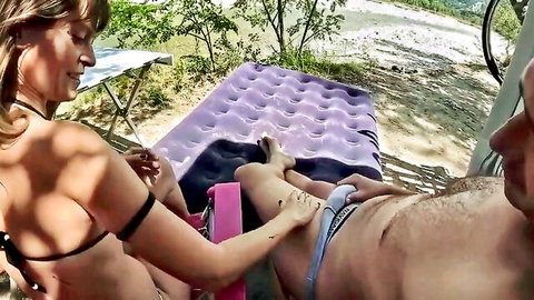 Blonde woman in bikini teases man's bulge outdoors in erotic scene