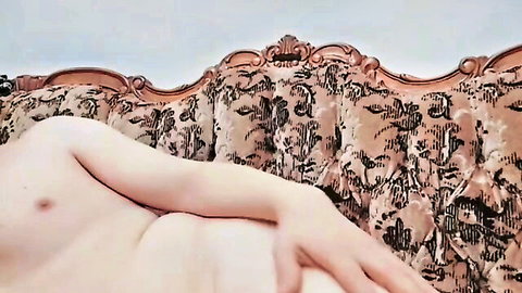 Curvy nude BBW lying sideways on ornate vintage couch exposing side tits and plump hips
