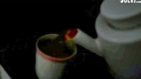 Teapot pouring steaming red tea into white cup closeup