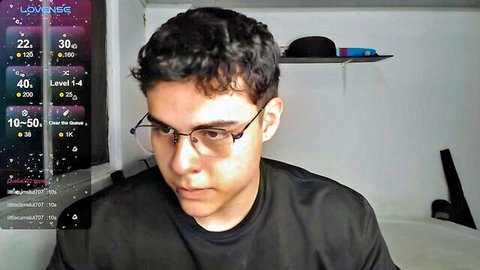 Brunette guy in glasses on webcam looking down intently in black t-shirt