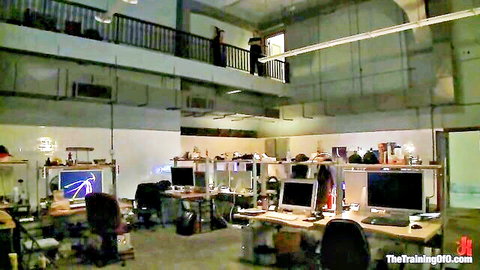 Empty industrial training room with computer desks, monitors, chairs and mezzanine balcony