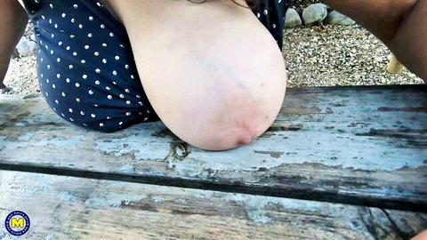Mature granny exposes huge saggy natural tits topless outdoors on picnic table