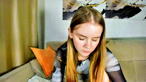 Young blonde teen in sheer black top teasing perky tits on webcam couch