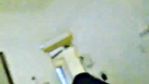 Blurry closeup of yellow-handled white plunger on green bathroom floor