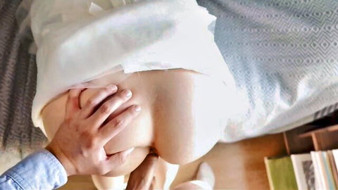 Man grabs bride's bare ass cheeks pulling up white wedding dress doggy style on bed