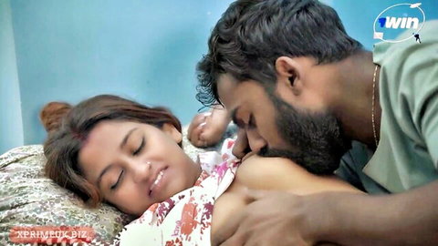Bearded Indian man passionately kisses neck and gropes exposed tits of smiling desi woman on bed