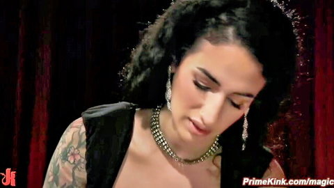 Arabelle Raphael in seductive femdom pose with huge tits and tattoos
