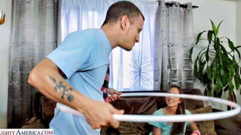 Tattooed stud teases smiling Asian babe with hula hoop on her lap in playful foreplay