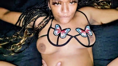 Sexy ebony babe in black butterfly lingerie exposing natural tits, lying seductively