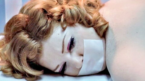 Laura Hippe gagged with tape, topless redhead in vintage porn scene