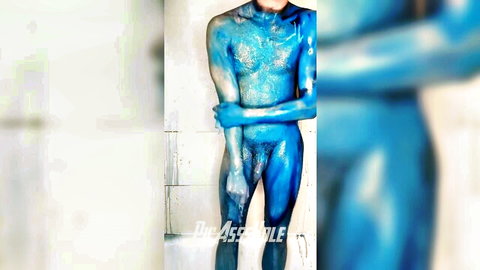 Naked muscular stud covered in shiny blue body paint exposes his big blue cock arms crossed in shower
