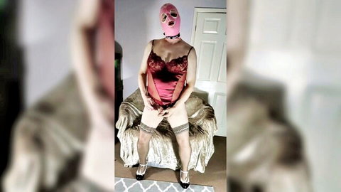 Pink masked sissy in sheer red lace lingerie garters and stockings poses spreading legs seductively