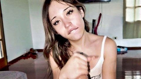 Naughty petite teen pouts with fingers teasing her lips in tight white tank top