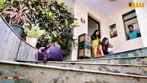 Indian chachi in colorful sari on stairs with nephew peeking
