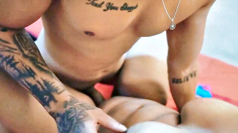 Tattooed muscular man fingers nude babe's pussy passionately on red towel