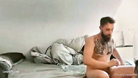 Tattooed bearded man grips naked guy's ass sliding cock inside doggy style on bed