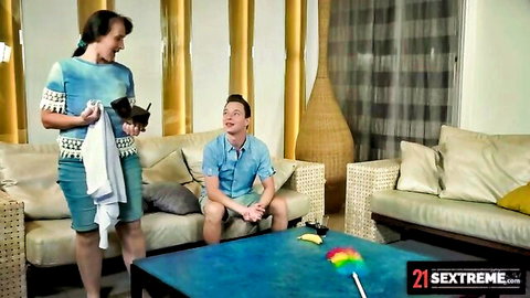Nikki Nuttz as horny mature maid in blue outfit with feather duster