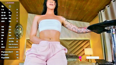 Tattooed Asian ladyboy in white tube top and pink sweatpants webcam tease