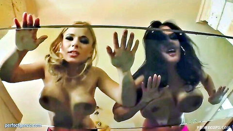 Busty blonde and brunette babes squish huge tits against steamy shower glass smiling seductively
