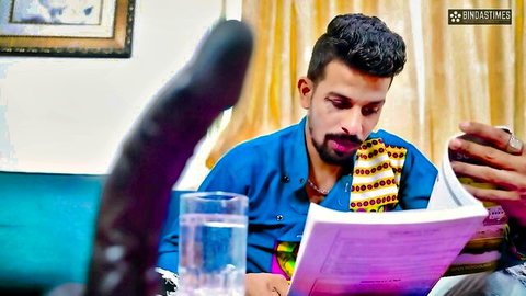 Indian man with beard reading book while huge black dildo teases his crotch