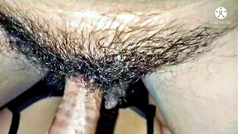 Thick erect cock shaft emerging from dense bushy black pubic hair closeup
