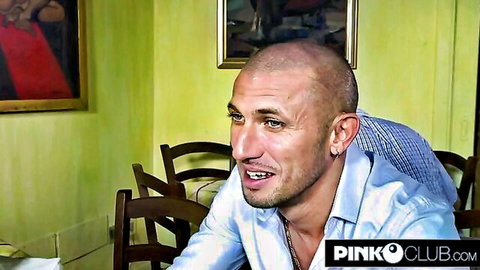 Bald Caucasian man in blue shirt talking at table in Pinko Club room