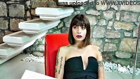 Silvia Soprano in strapless black V-neck dress, tattoos, seductive sit