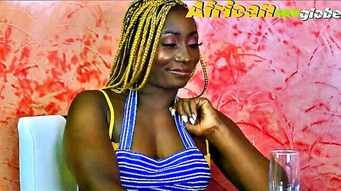 Sexy African Latifah smiling in low-cut blue striped top, yellow braids