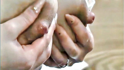 Japanese woman squeezing breasts, milk squirting from nipples close-up