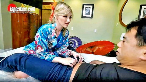 Melody Marks in floral kimono touching Asian man on bed massage scene