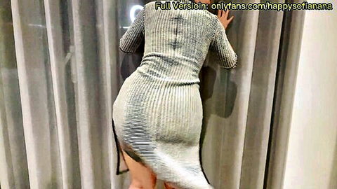 Asian woman in tight grey cheongsam-style dress teasing curves from behind