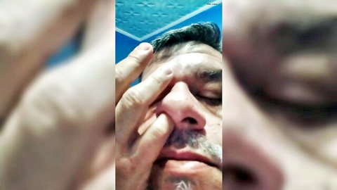 Blurry close-up of bearded man digging nose in solo fetish session