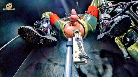 Woman in green latex suspended in bondage with apparatus
