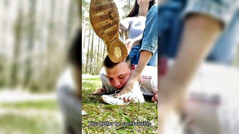 Mistress tramples humiliated slave's head into grass with dirty sneaker in outdoor femdom foot domination