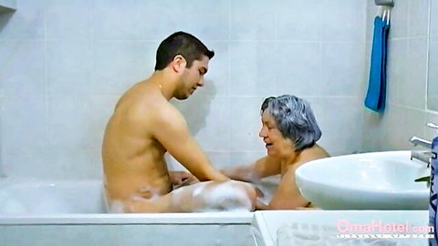 Hairy grandma in foamy bathtub with nude young man, OmaHoteL threesome preview