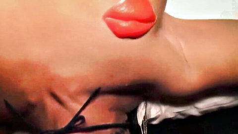 Seductive close-up of trans woman's red lips and brown skin in intimate pose