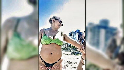 Pregnant blonde in green bikini making out publicly on beach