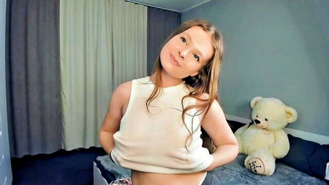 Teen webcam girl with big tits lifts thin white tank top teasing underboob and hard nipples beside teddy bear