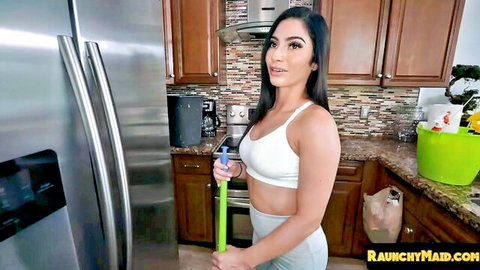 Brunette maid in tight white bra and gray shorts holding mop teasing big tits in kitchen