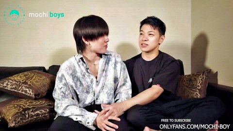Two young athletic East Asian twinks teasing intimately on couch in gay promo
