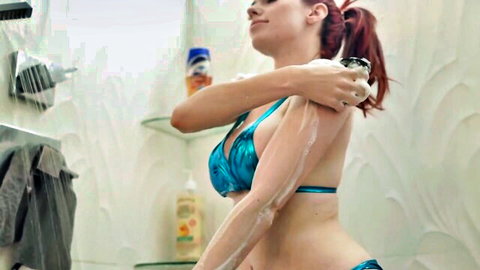 Skinny redhead in blue bikini lathering soapy suds on tits and arms in steamy bathroom shower