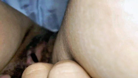 Close-up of shaved Asian pussy as woman cleans clitoris with black cotton swab