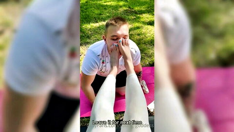 Man worships young goddess's bare feet in outdoor foot fetish scene