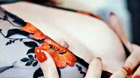 Busty beauty in floral lace lingerie, teasing cleavage reveal with red nails