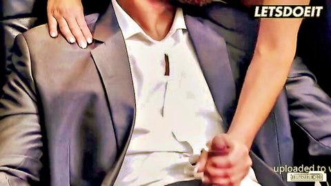 Babe's hand grips thick hard cock bulging from suited man's open pants in office tease