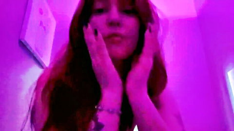Jadedfreak redhead camgirl posing playfully in purple light