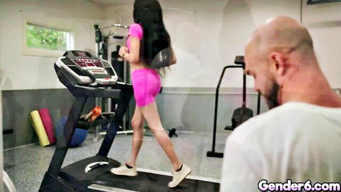 Ariel Demure in pink gym outfit on treadmill, bald man watching from behind