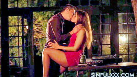 Passionate couple kissing intimately, woman in red dress with long hair