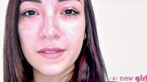 Close-up of cute freckled teen girl with glossy lips and dark eyes smiling seductively