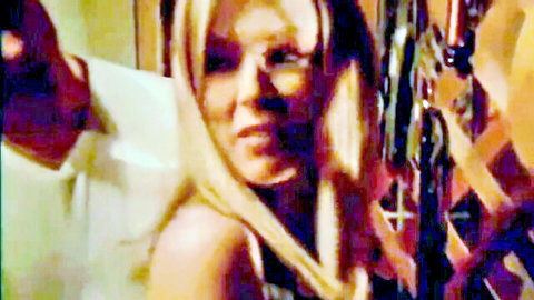 Vintage blonde babe in low-cut white top smiles seductively as man's hand gropes her shoulder